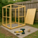Partially built wooden garden shed on a level slab base with tools and a spirit level in a small UK garden