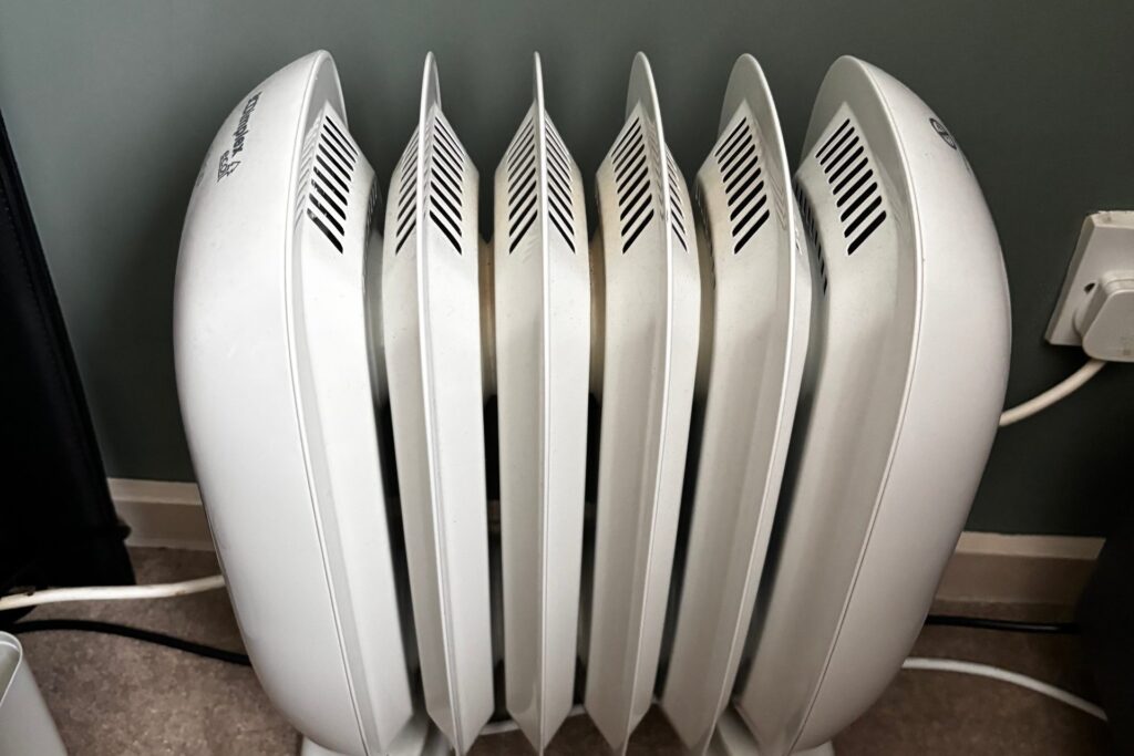 Our own Dimplex Eco Chico oil-free heater in the spare room, side-on with its six white fins, plugged in at the wall