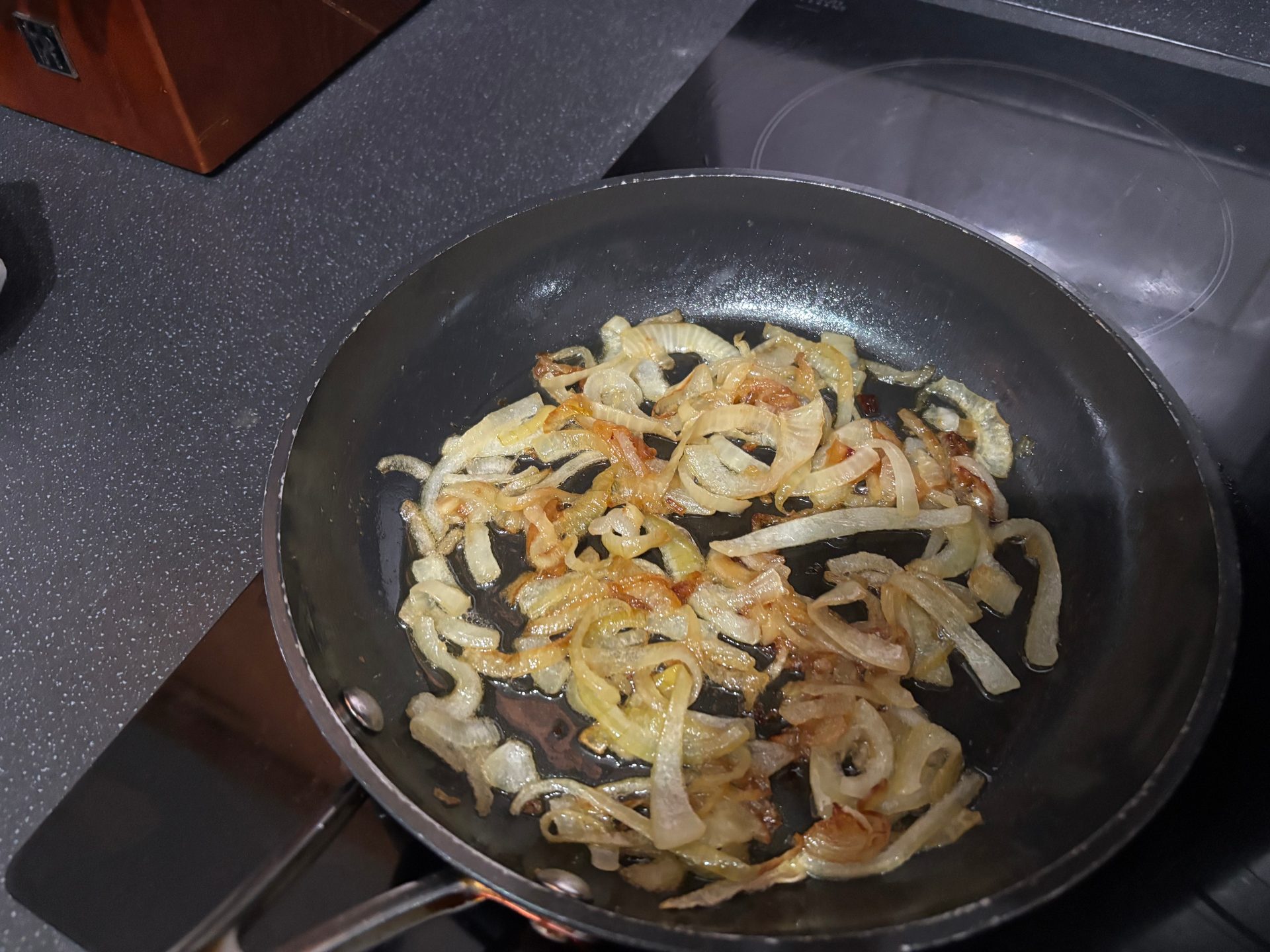 Sliced onions softening and starting to colour in a frying pan for the gravy